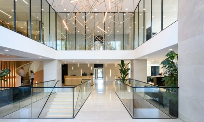Modern office atrium with glass walls, open floors and designer lighting