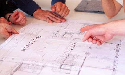 Team discussing architectural drawings and floor plans during a design meeting
