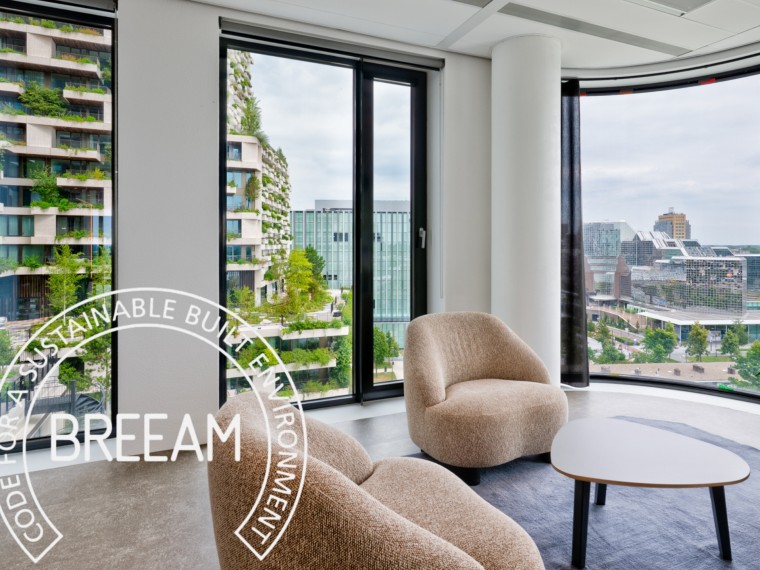 Modern kantoorinterieur door BESPARK met twee fauteuils en uitzicht op duurzame, groen beplante gebouwen, voorzien van een BREEAM-keurmerkoverlay