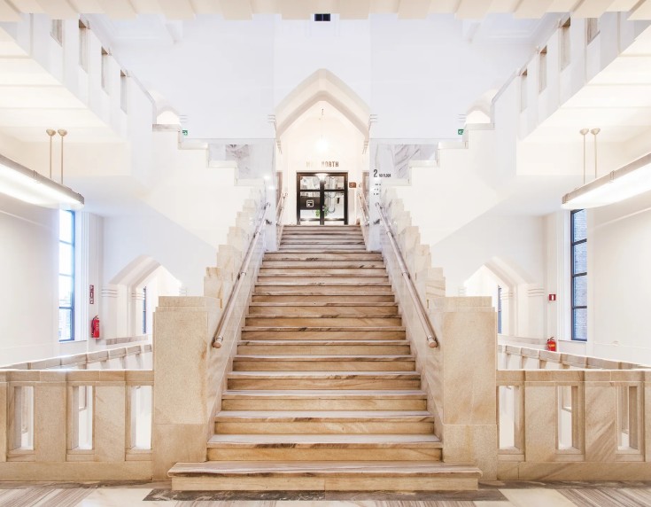 Modern kantoorinterieur in een monumentaal pand met natuurlijk licht en een warme, open sfeer.