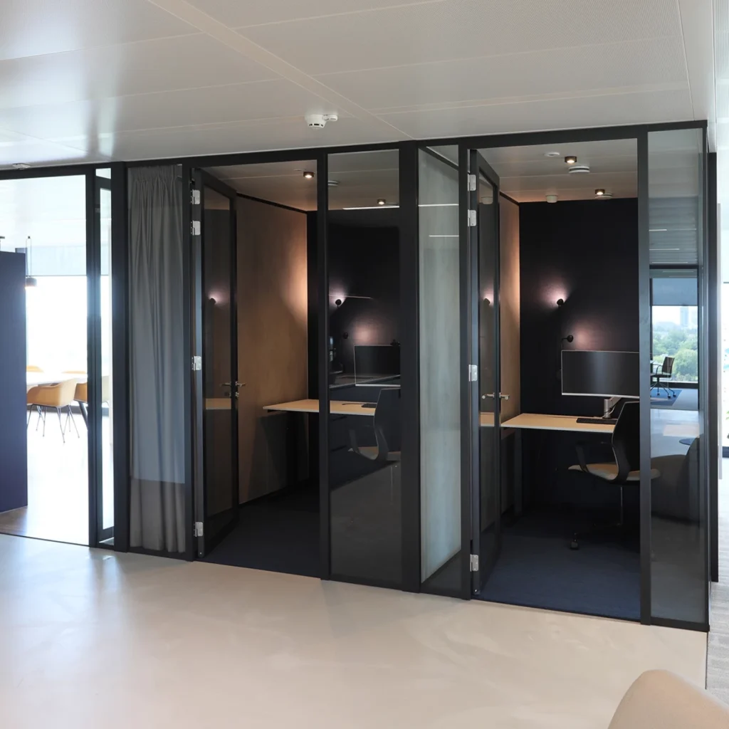 Moderne kantoorruimte met glazen wanden en flexibele werkplekken.