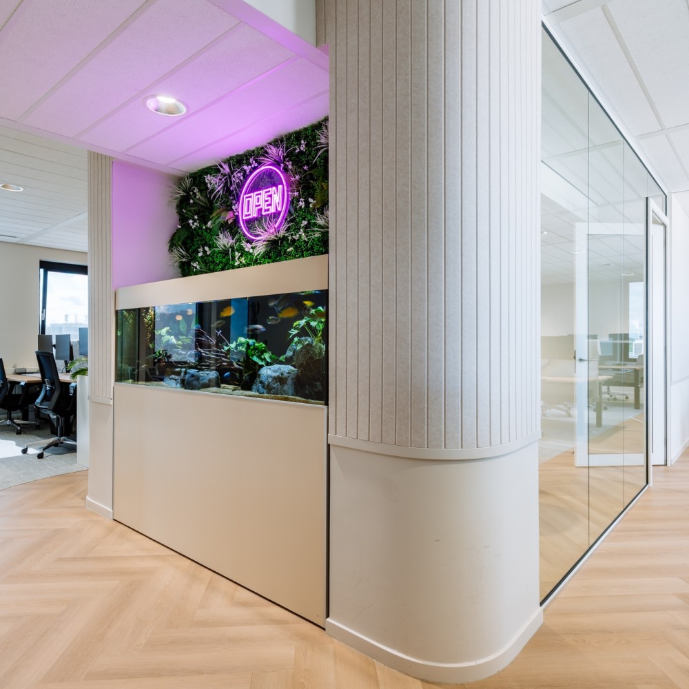Een modern kantoorinterieur met een groot aquarium en een verlicht "OPEN" bord aan de muur.