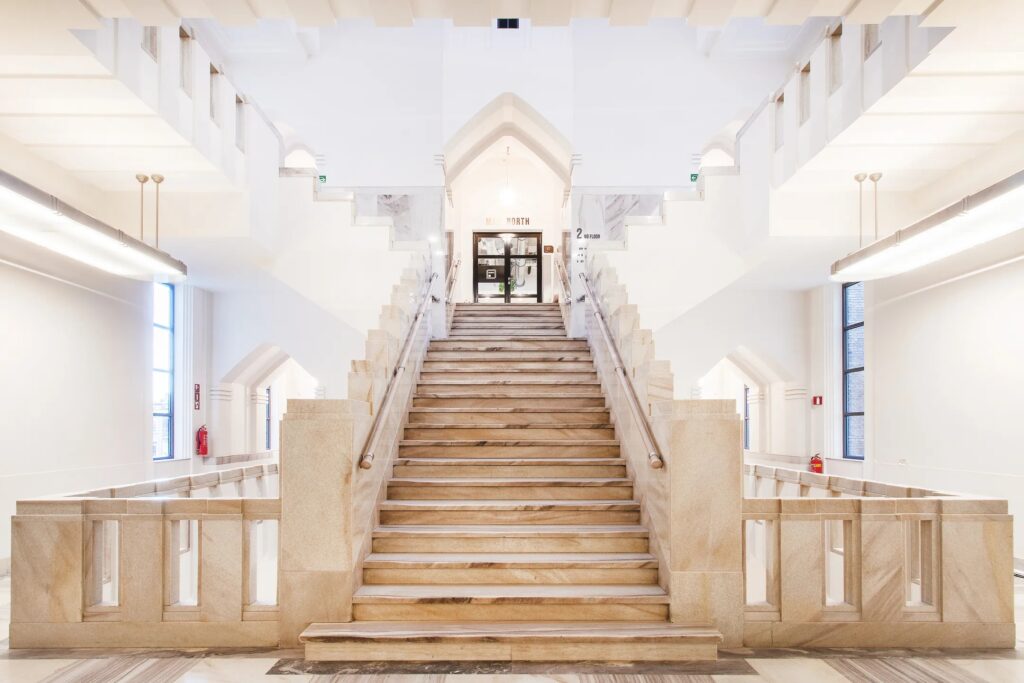 Modern kantoorinterieur in een monumentaal pand met natuurlijk licht en een warme, open sfeer.