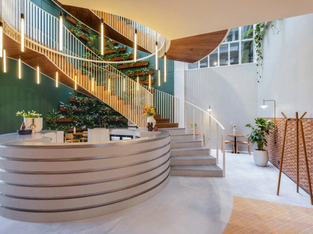 Moderne lobby van Bespark Rembrandtplein met plantenwand en wenteltrap.