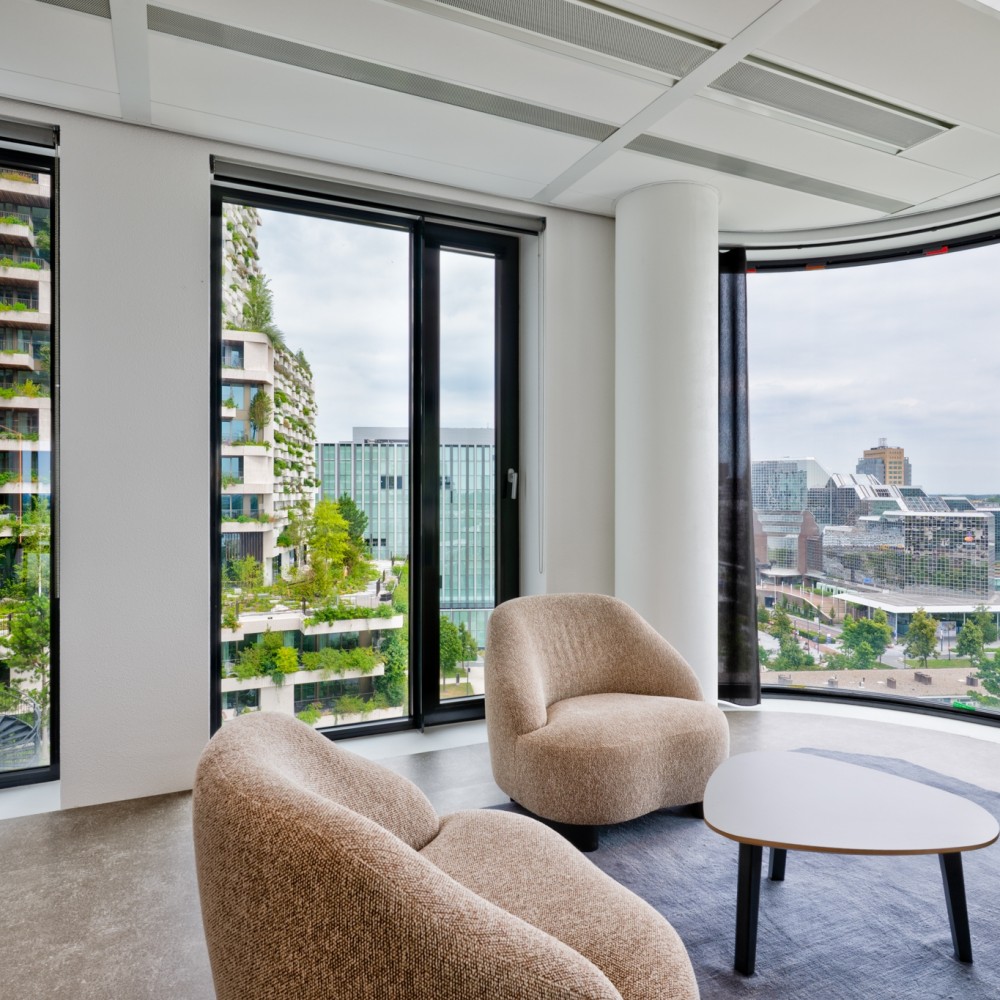 Uitzicht op moderne architectuur met groene gevels vanuit een stijlvol ingericht interieur.