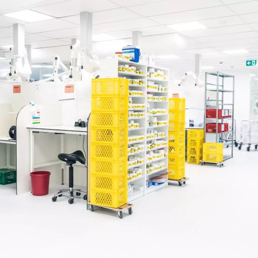 Een cleanroom met gekleurde kratten en opslagplanken vol producten.