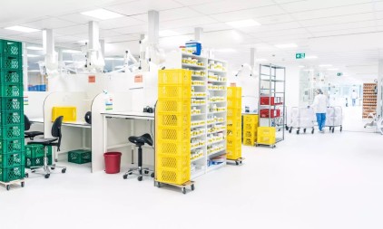 Cleanroom productieproces met gekleurde kratten en werkstations.