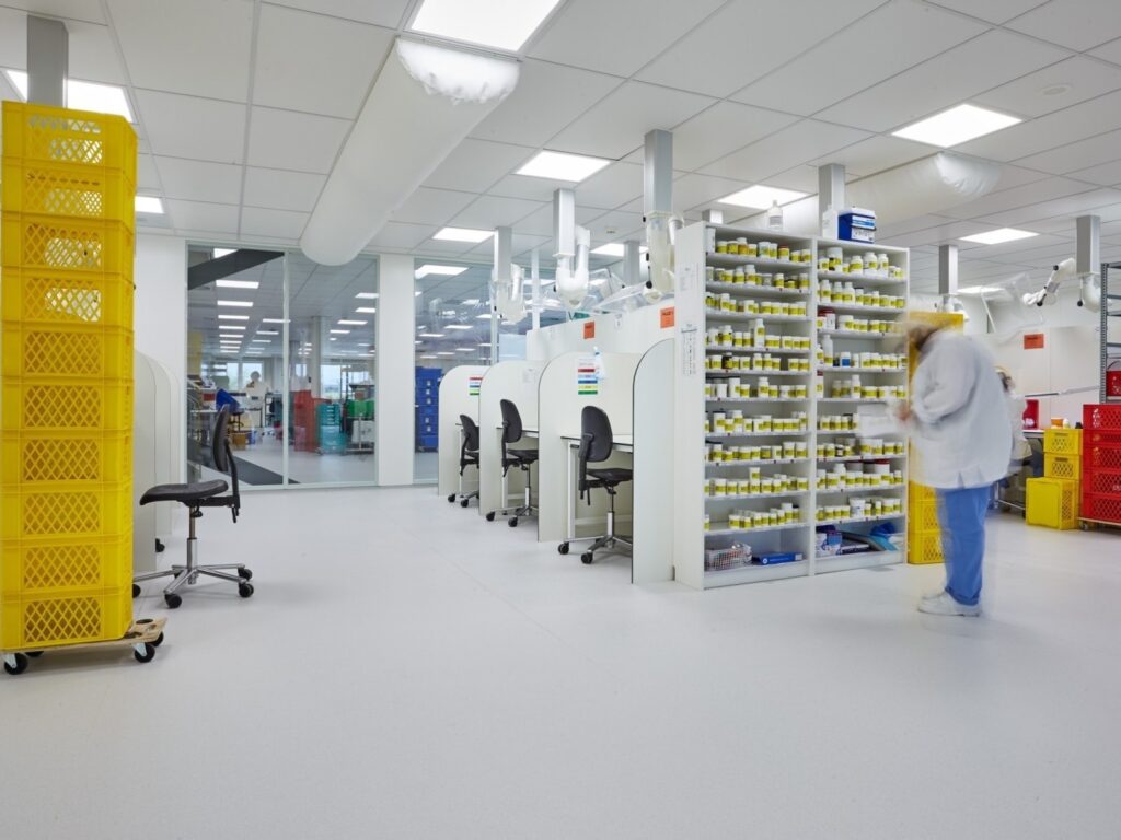 Een farmaceutisch laboratorium met een persoon die medicijnen in de rekken bekijkt.