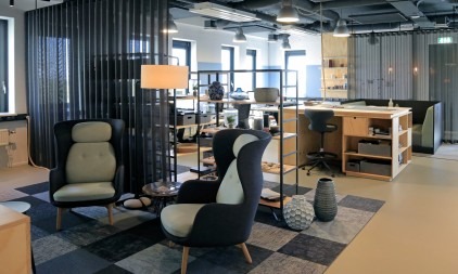 Creatieve studio-werkruimte met moderne lounge stoelen en bureaus in een open kantooromgeving.