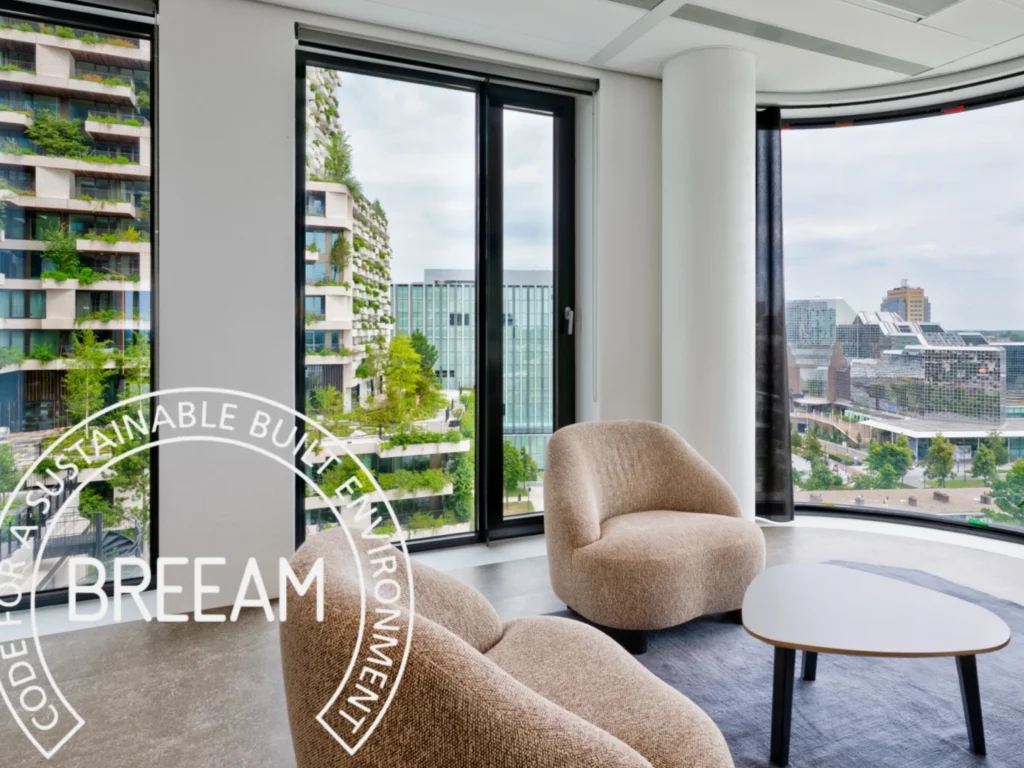 Uitzicht vanuit een modern kantoor op een duurzaam gebouw met groene gevels, voorzien van BREEAM-certificering.